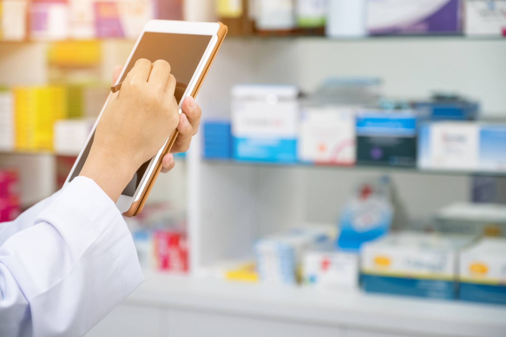 Pharmacist working with a tablet computer in the pharmacy holdin